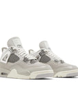 Pair of Jordan 4 Retro Frozen Moments Women's in grey and silver.