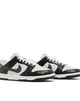 Pair of Nike Dunk Low Black Total Orange Mini Swoosh in black, white and orange.