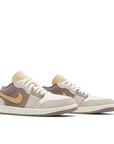 Pair of Jordan 1 Low SE Craft Taupe Haze in Brown, Grey and Sail.