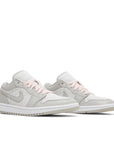 Pair of Jordan 1 Low SE Light Iron Ore (W) in Grey.