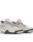 Pair of Jordan 4 Retro SE Craft Photon Dust (GS) in shades of grey