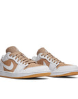 A pair of the Nike Air Jordan 1 Low Hemp White basketball shoe is in a white and hemp colourway.