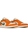 A pair of the Nike Air Jordan 1 Low Orange Olive basketball shoes are in an orange and green colourway.