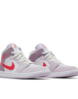 A pair of Jordan 1 Mid Valentine's Day (2022) (w) is in a pink and red colourway