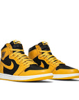 A pair of Nike Air Jordan 1 Retro High Pollen basketball shoes in yellow and black