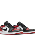 A pair of Nike Air Jordan 1 Low Bred Toe sneakers in black and red