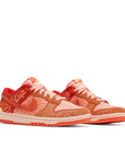 A pair of Nike Dunk Low NH Winter Solstice womens sneakers in orange and yellow