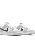 A pair of Nike Dunk Low SE Lottery Pack sneakers in grey