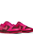 A pair of Nike Dunk Low Valentines Day 2022 womens sneakers in pink and red