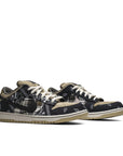 A pair of Nike sb dunk low Travis Scott skating shoes in a white and blue plaid and paisley colour