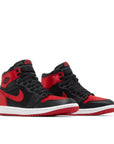 Pair of Jordan 1 Retro High OG Satin Bred (W) in black and red