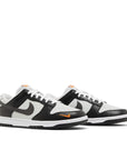 Pair of  Nike Dunk Low Black Total Orange  Mini Swoosh in black, white and orange.