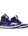 A pair of women's Nike Air Jordan 1 High Zoom CMFT Purple Patent basketball shoes in purple and black