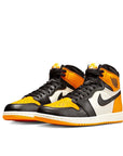 A pair of Nike Air Jordan 1 Retro High Yellow Toe Taxi basketball shoes in yellow, white and black
