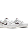 A pair of gradeschool Nike Dunk Low SE Jackpot GS childrens sneakers in white and grey