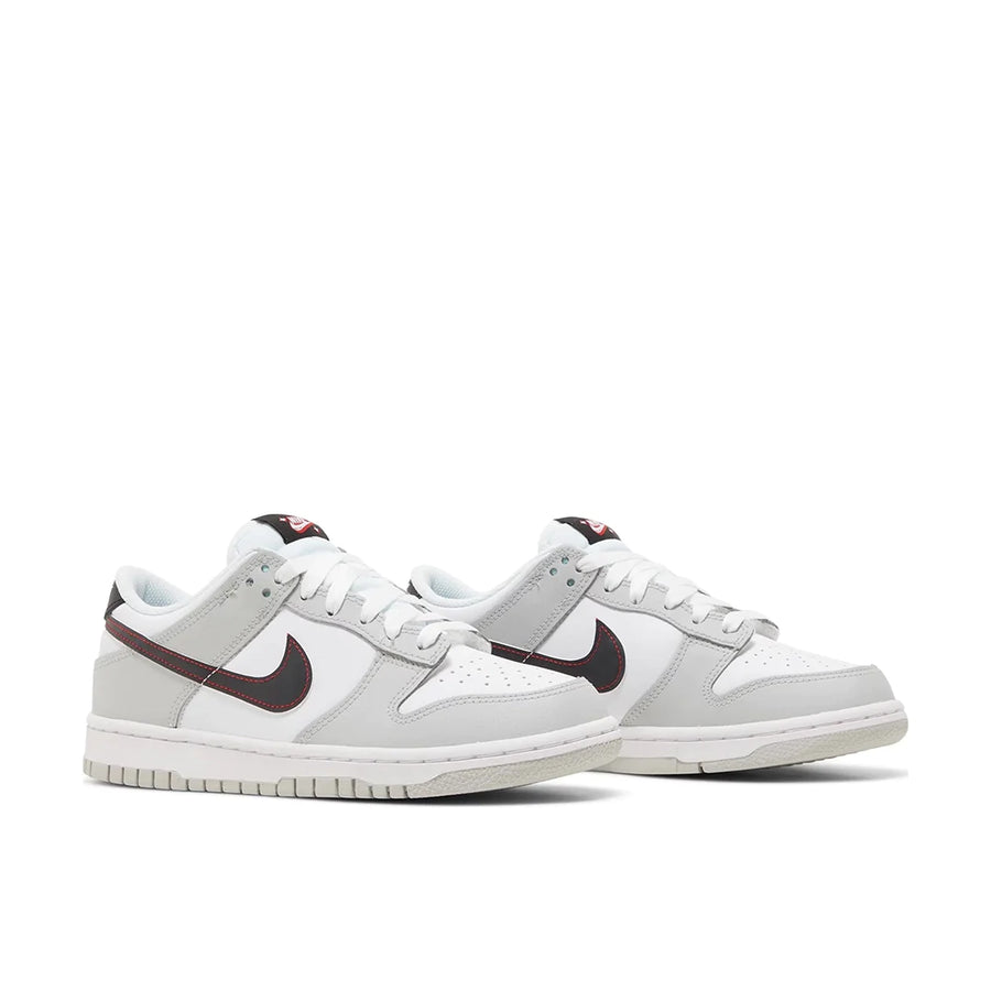 A pair of gradeschool Nike Dunk Low SE Jackpot GS childrens sneakers in white and grey