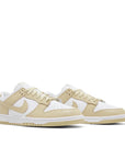 pair of Nike Dunk Low team gold in white and gold