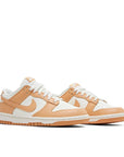 Pair of Nike Dunk Low Harvest Moon (W) in white and light brown.
