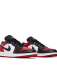 Pair of Jordan 1 Low Bred Toe (GS) in red, white and black.