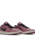 A pair of women's Nike Air Jordan 1 Low Mulberry sneakers in purple and black