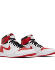 A pair of Nike Air Jordan 1 Retro High OG Heritage basketball shoes in red and white