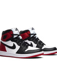 A pair of women's Nike Air Jordan 1 Retro High Satin-Black basketball shoes in black, red and white