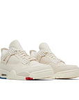 A pair of Air Jordan 4 blank canvas is in a sail, cement grey and fire red colourway