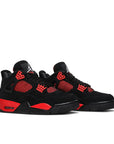 A pair of Nike Air Jordan 4 Retro Red Thunder basketball shoes in black and red