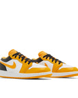 A pair of grade school Nike Air Jordan 1 Low Taxi children shoes in black, yellow and white
