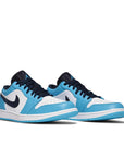 A pair of Nike Air Jordan 1 Low UNC sneakers in white and blue