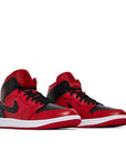 A pair of Nike Air Jordan 1 Mid Reverse Bred baskteball shoes in black and red