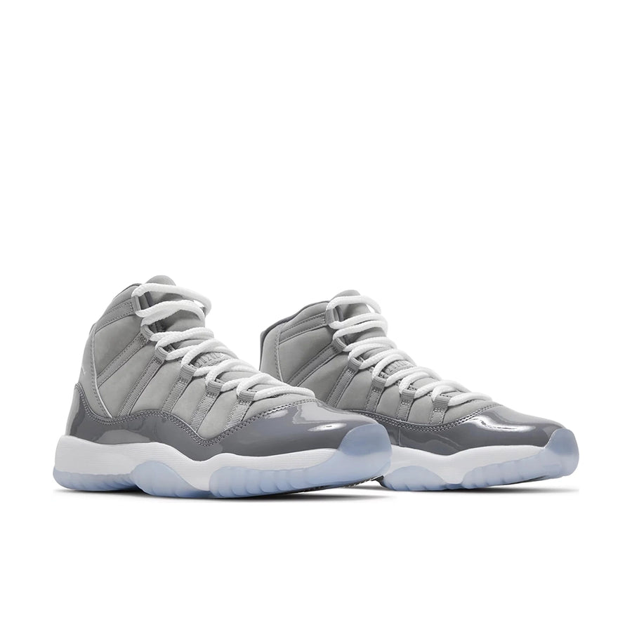 A pair of grade school kids Nike Air Jordan 11 cool grey basketball shoes in grey and white