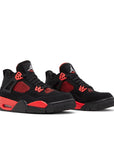 A pair of grade school kids Nike Air Jordan 4 red thunder basketball shoes in black and red