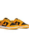 A pair of the Nike dunk low championship goldenrod in a black and yellow colour