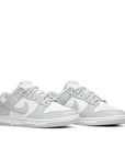 A pair of the Nike dunk lows in a grey white "grey fog" colour