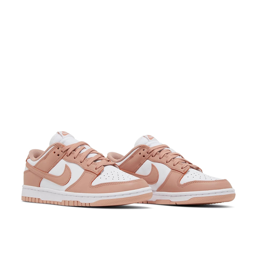 A pair of the womens Nike dunk lows in a white peach "rose whisper" colour