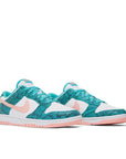 A pair of Nike Dunk Low Snakeskin Washed Teal Bleached Coral womens sneakers