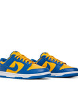 A pair of the Nike dunk lows in a yellow blue "ucla" colour