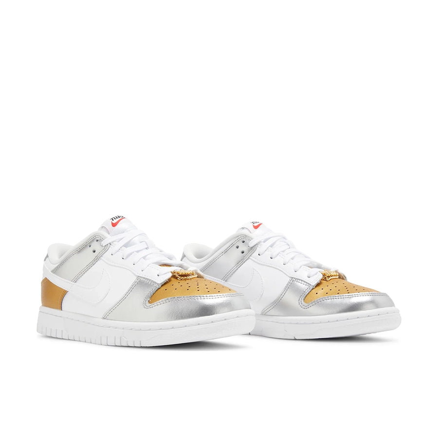 A pair of the Nike SB Dunk Low Heirloom womens shoe in white and gold