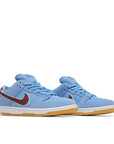 A pair of Nike SB Dunk Low Valour Blue Team Maroon skating shoes in blue and burgundy