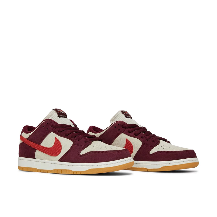 A pair of the Nike sb dunk low pro skate like a girl skating shoes in burgundy and cream